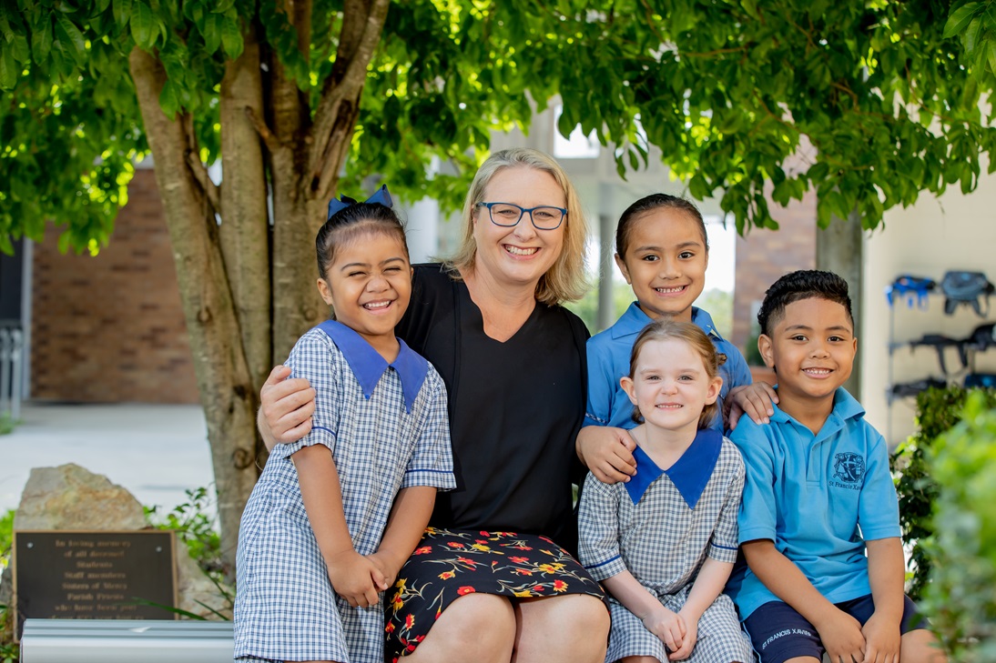 Four students sitting outside with Principal