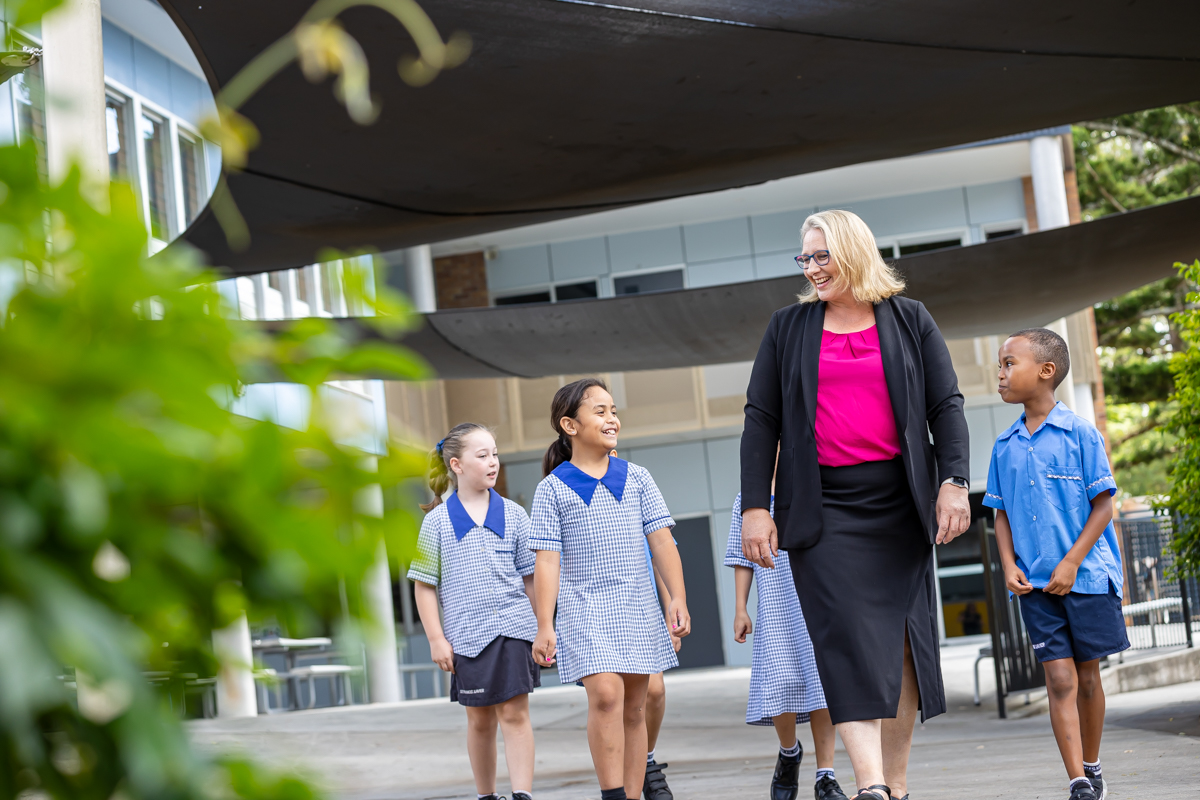 Principal walking with three students outside