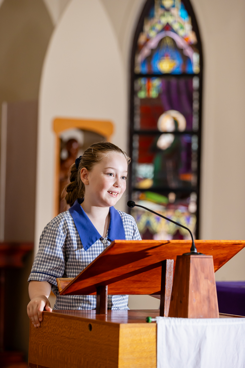 A student is standing at the podium in church doing a reading
