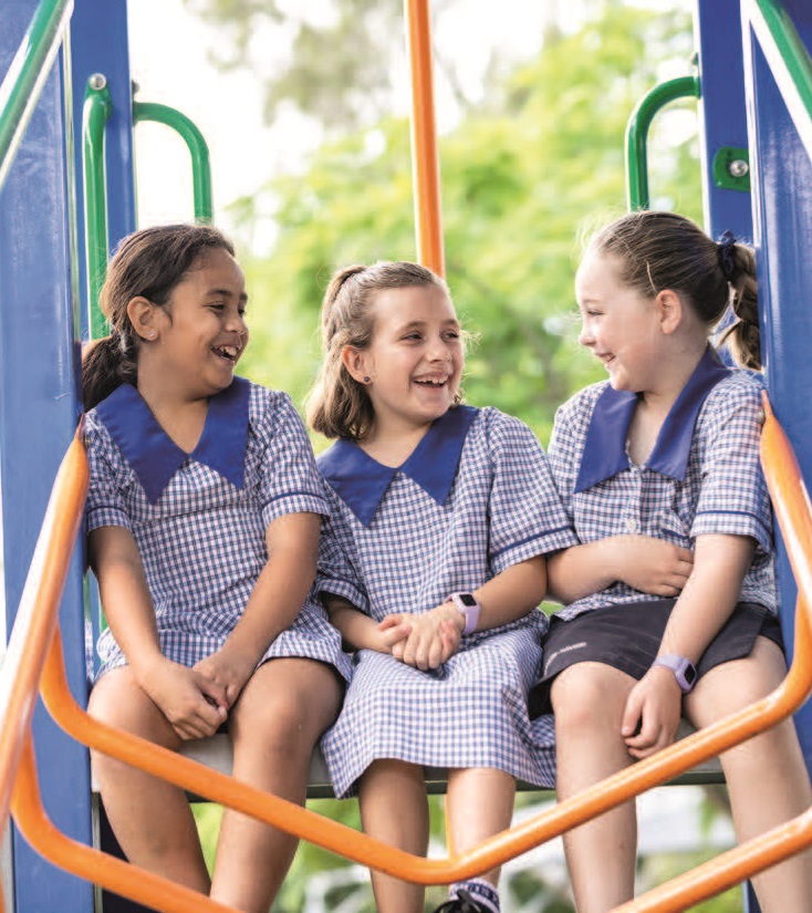 Three students sitting on a playground